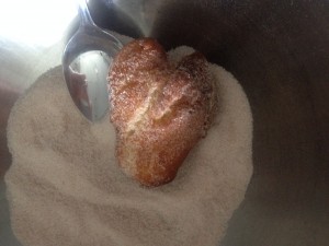 Krapfen in Zimt und Zucker wälzen