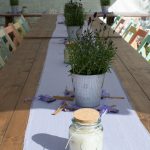 Tischdekoration: Selbstgemachte Lavendelkerze im Vordergrund